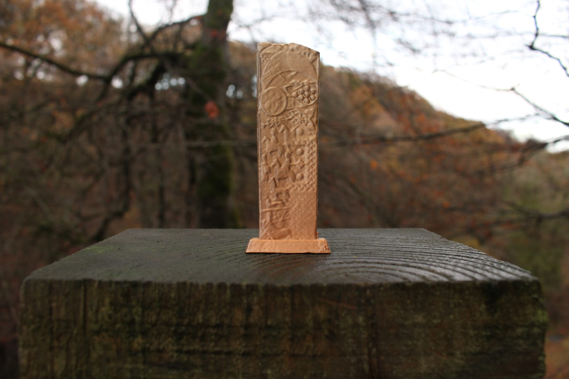Pictish Stone Remix 3D Printed Sculpture in Silk Metal against a woodland scene.